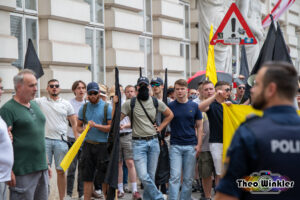 Silvio Neumaier in blauer Jeans und blauem T-Shirt links neben der IB Fahne auf der Demonstration 2024